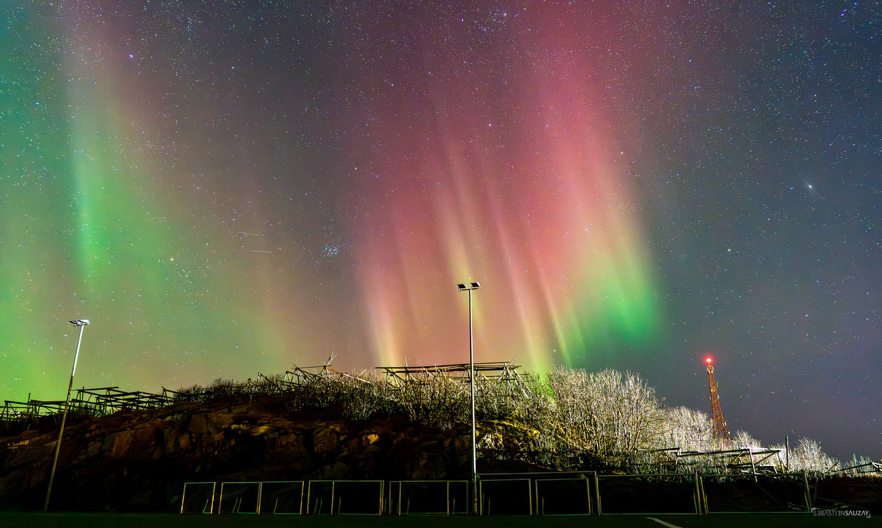 Auroras verdes y rosas sobre los secaderos de bacalao de Lofoten